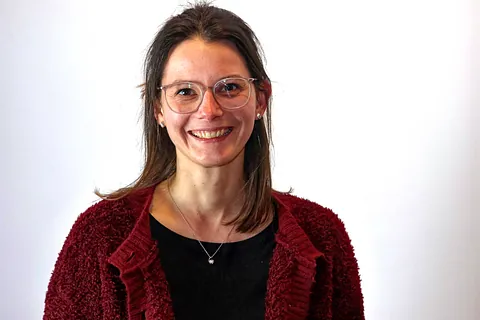 Eine junge Frau mit Brille und dunklen Haaren