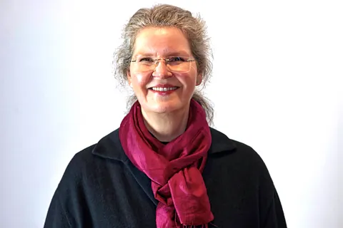 Eine Frau mit Brille und rotem Schal